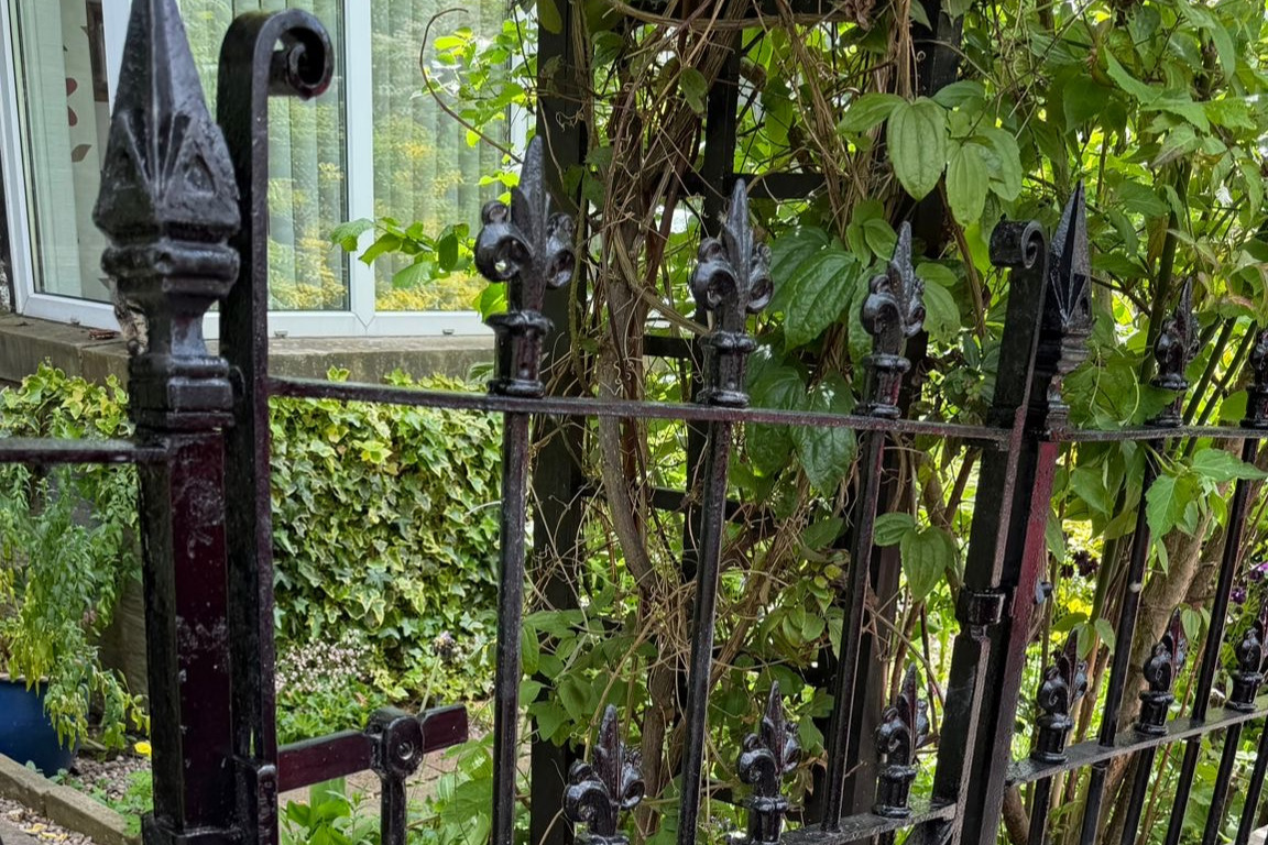 Restored metal gate or railing after stripping priming and respraying